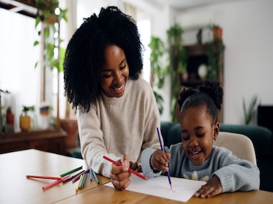 mother and daughter drawing on paper